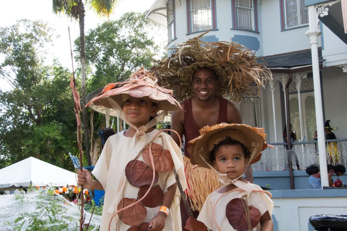Children and a performer wearing handmade Caribbean leaf costumes