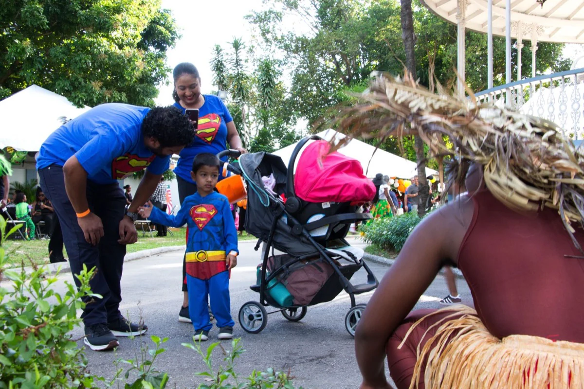 A family in superhero costumes meeting a performer at the event