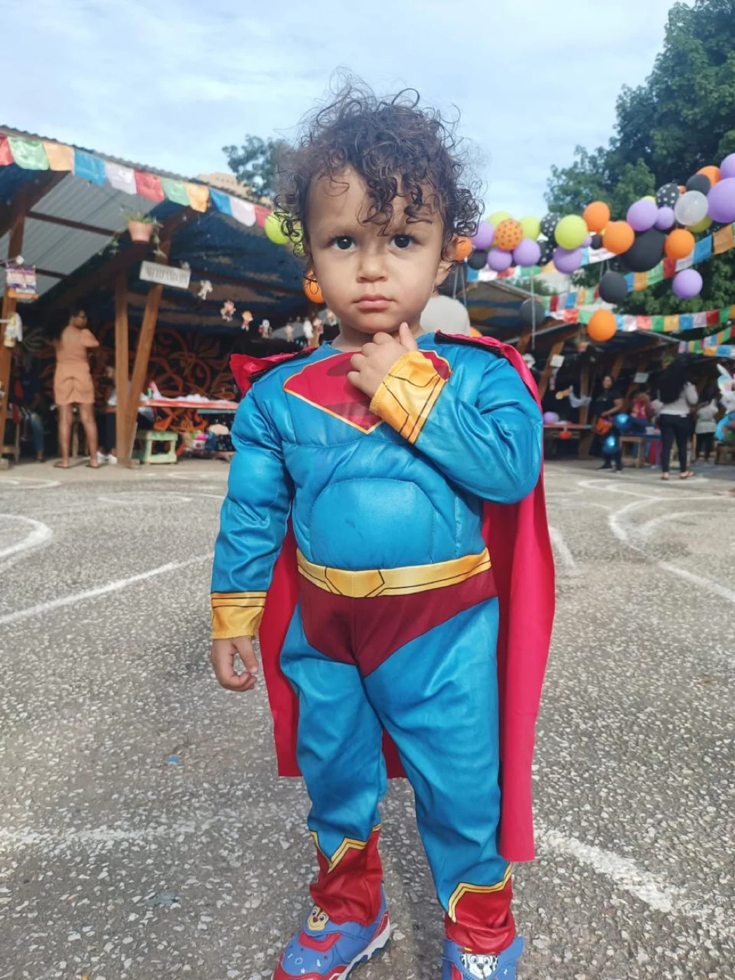 A young child dressed as a superhero at the community celebration